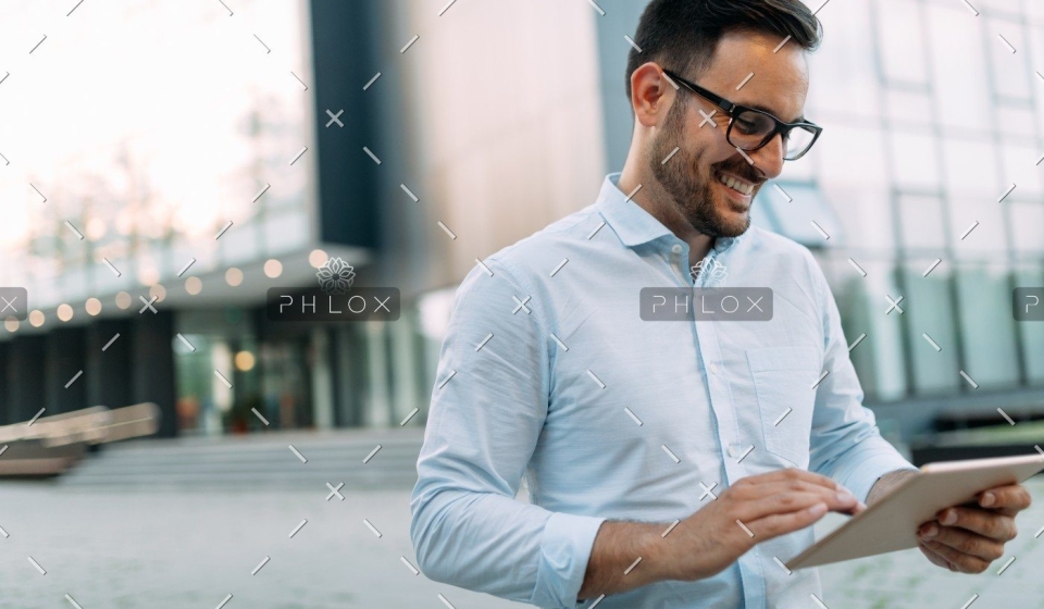 demo-attachment-448-portrait-of-businessman-in-glasses-holding-tablet-AWVHCJU